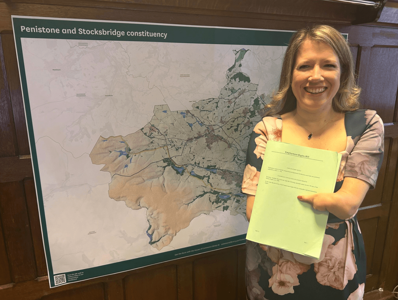 Marie Tidball holding employment rights bill in front of Penistone and Stocksbridge map